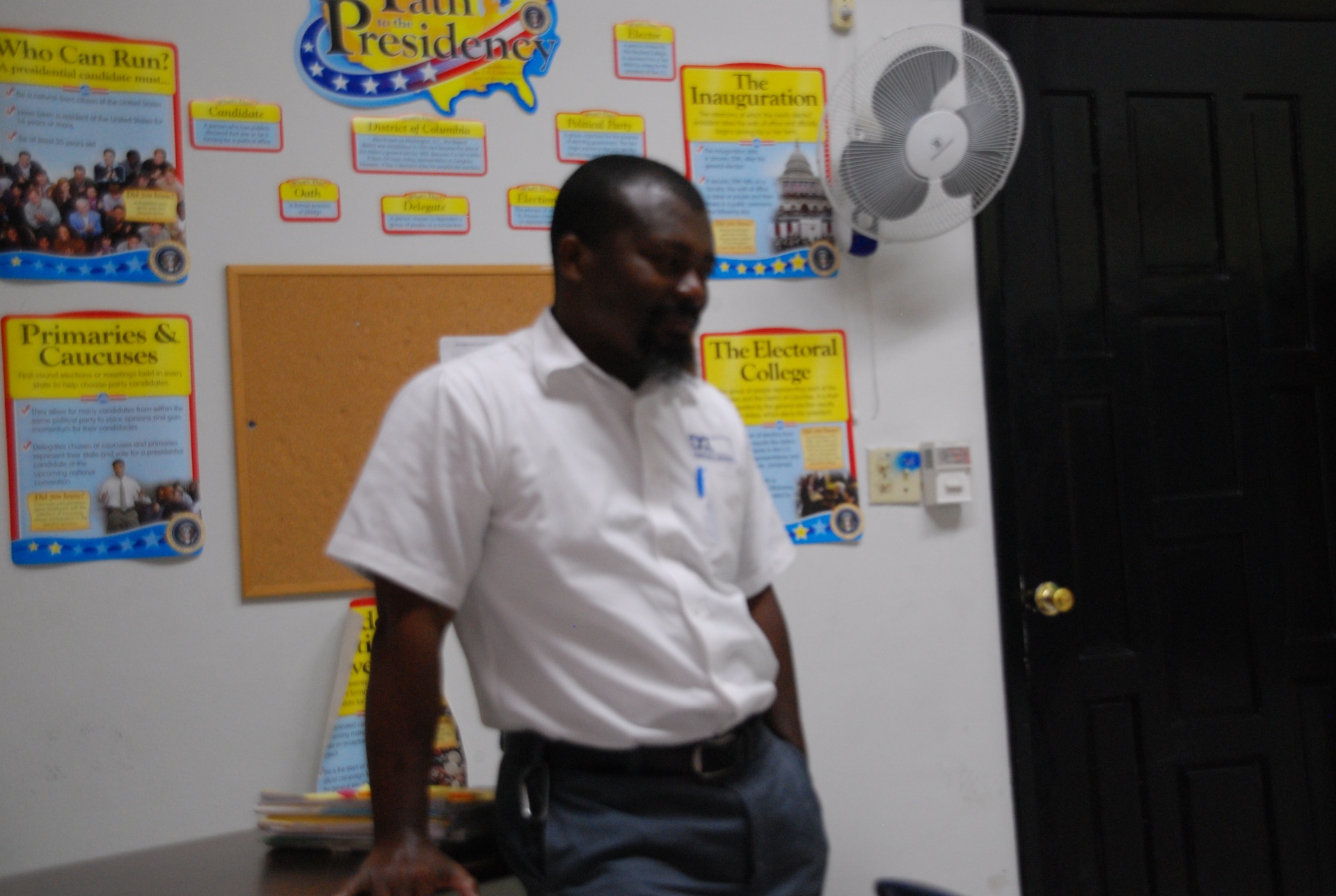 EXL mathematics teacher in front of a classroom bulletin board