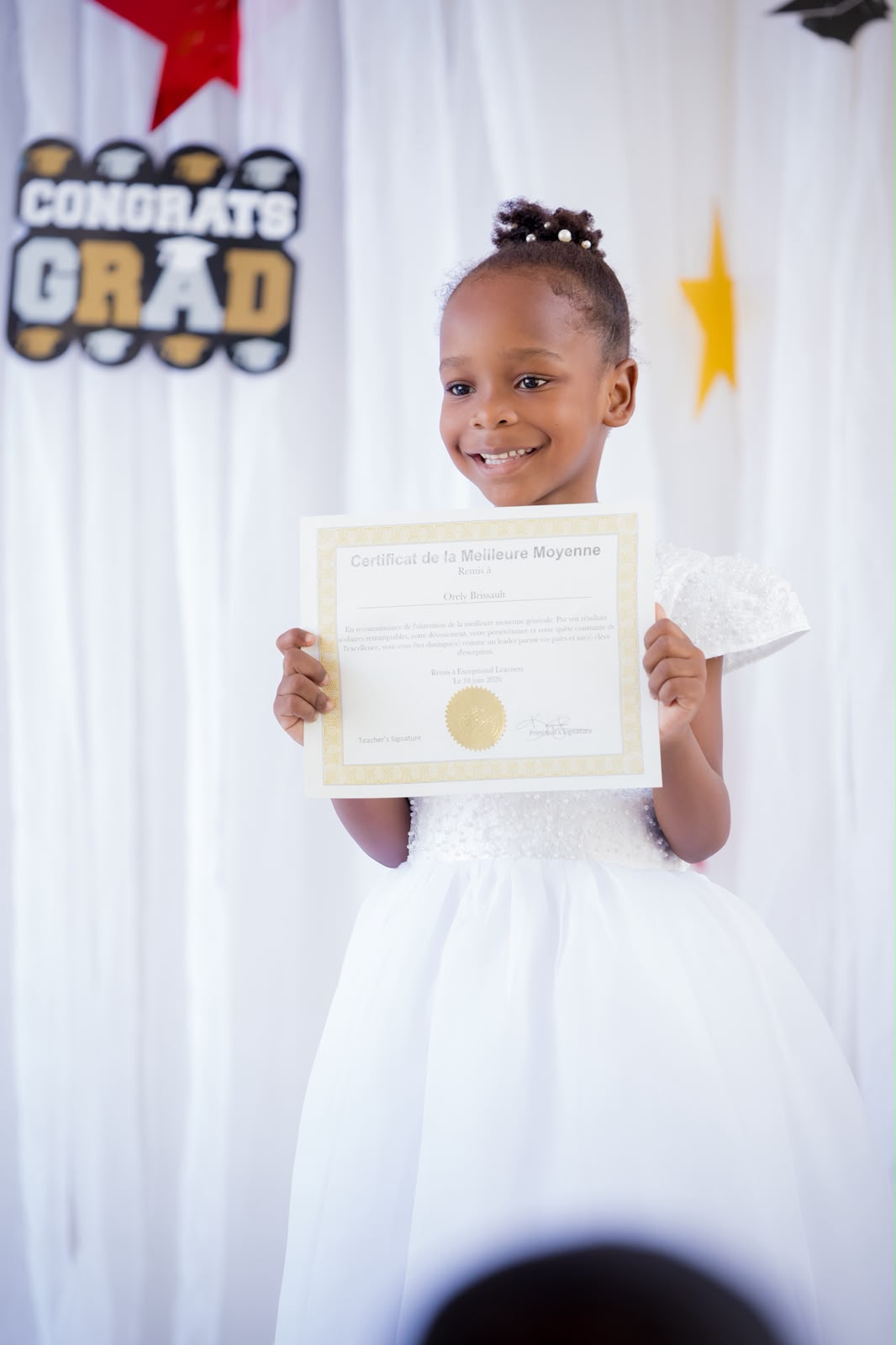 Young EXL graduate holding a Certificat de la Meilleure Moyenne