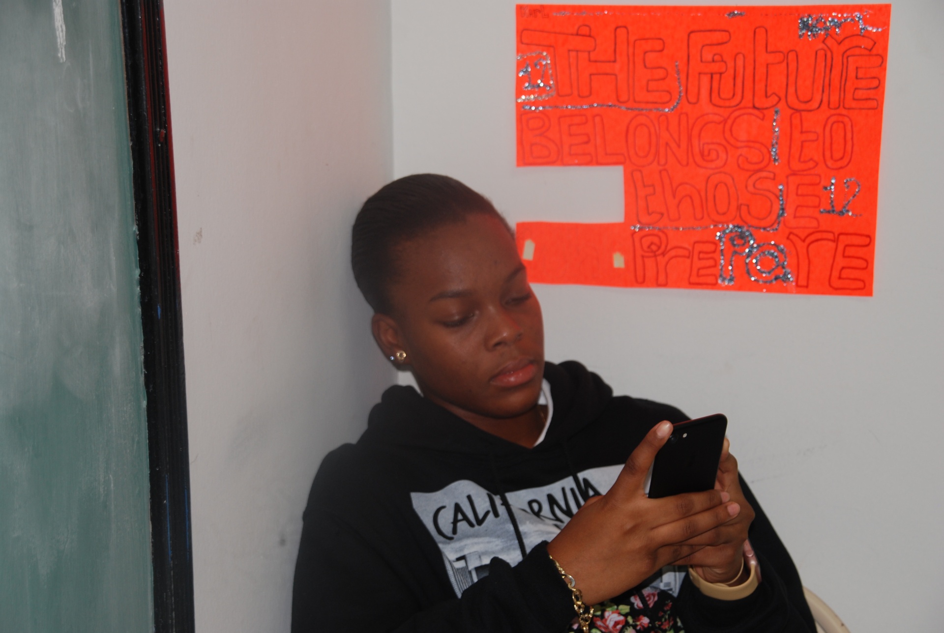 Student under a poster reading 'The future belongs to those who prepare'