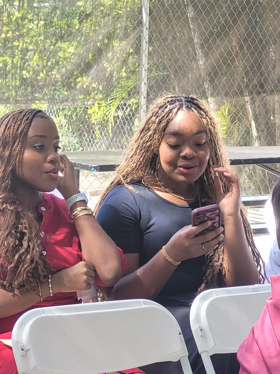 Two EXL high school students sitting together outdoors