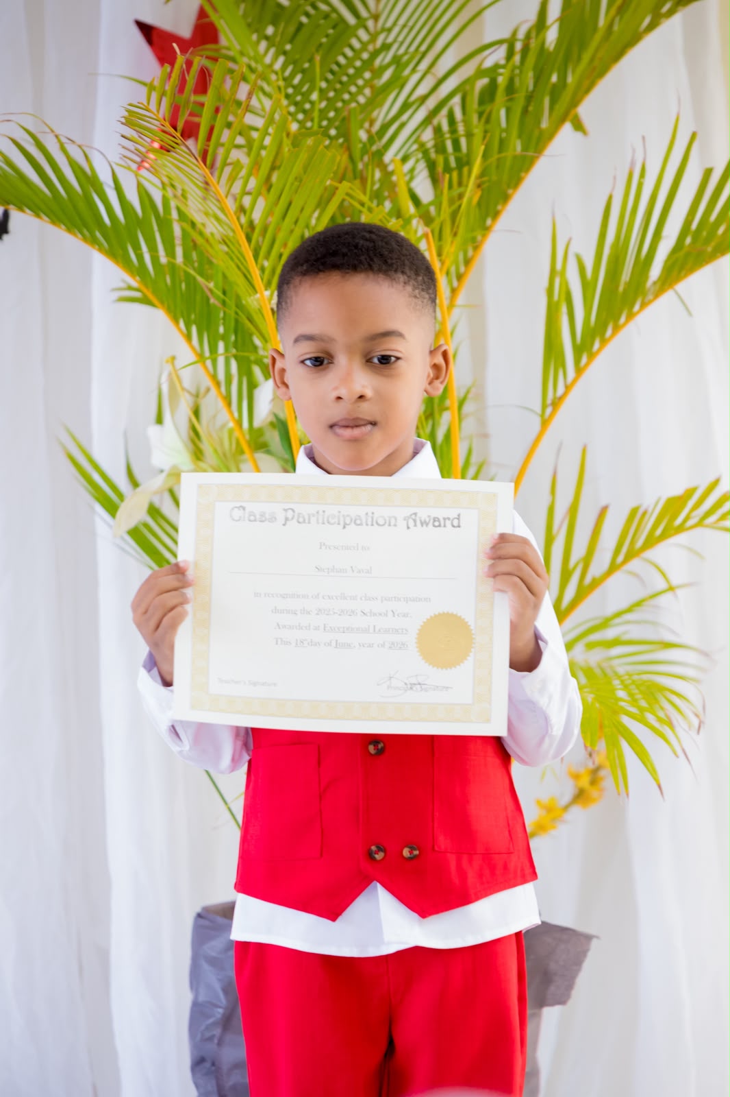 EXL student holding a Class Participation Award certificate
