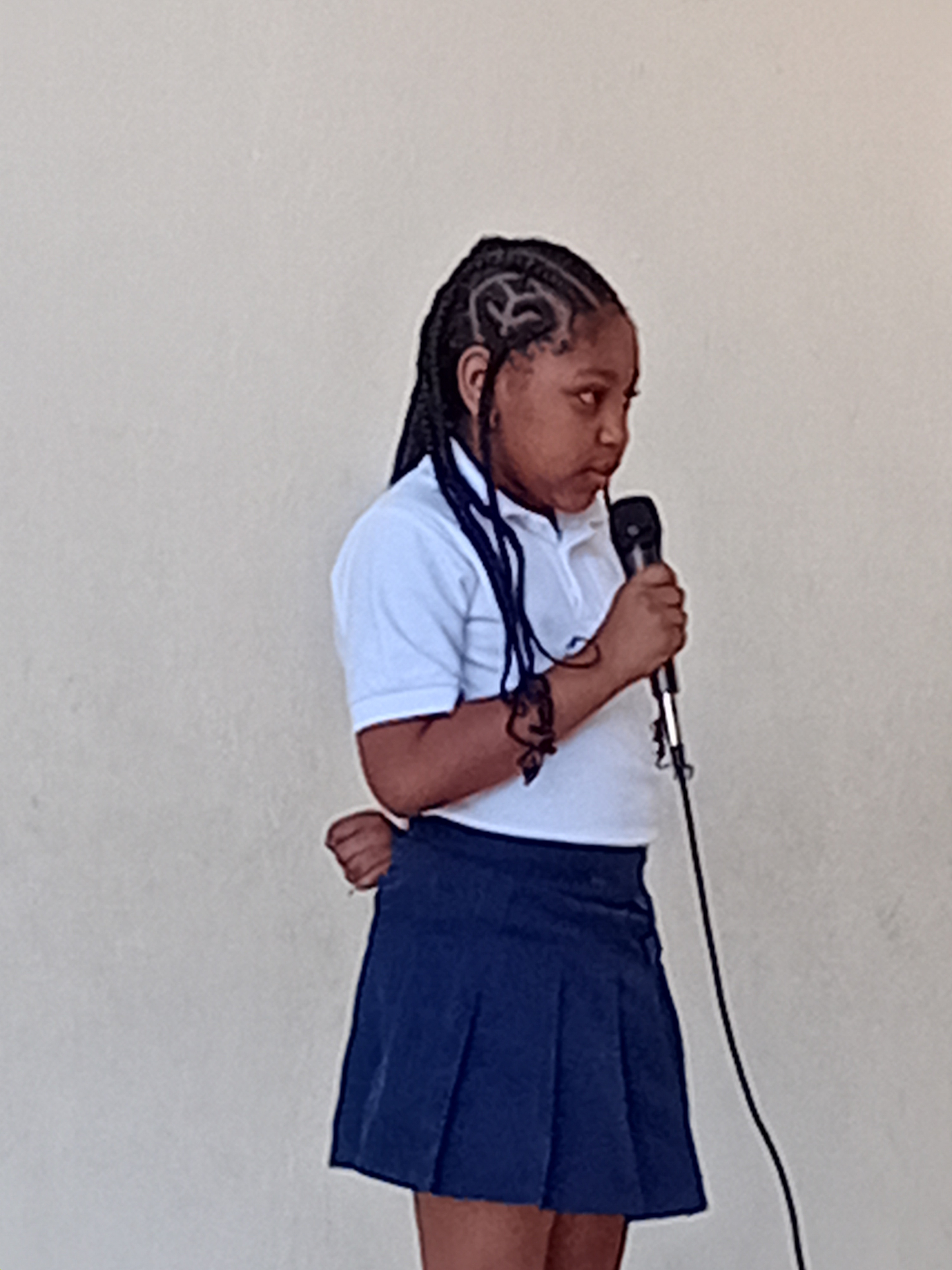 EXL student speaking into a microphone during a class presentation