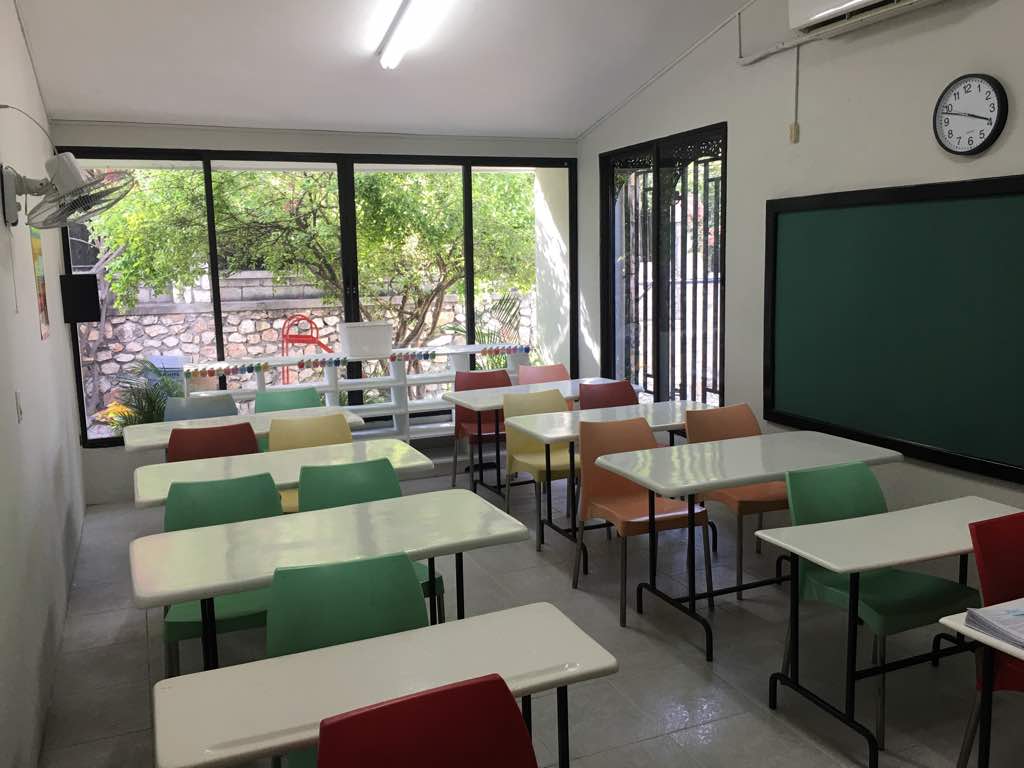 Bright classroom with colorful chairs and chalkboard