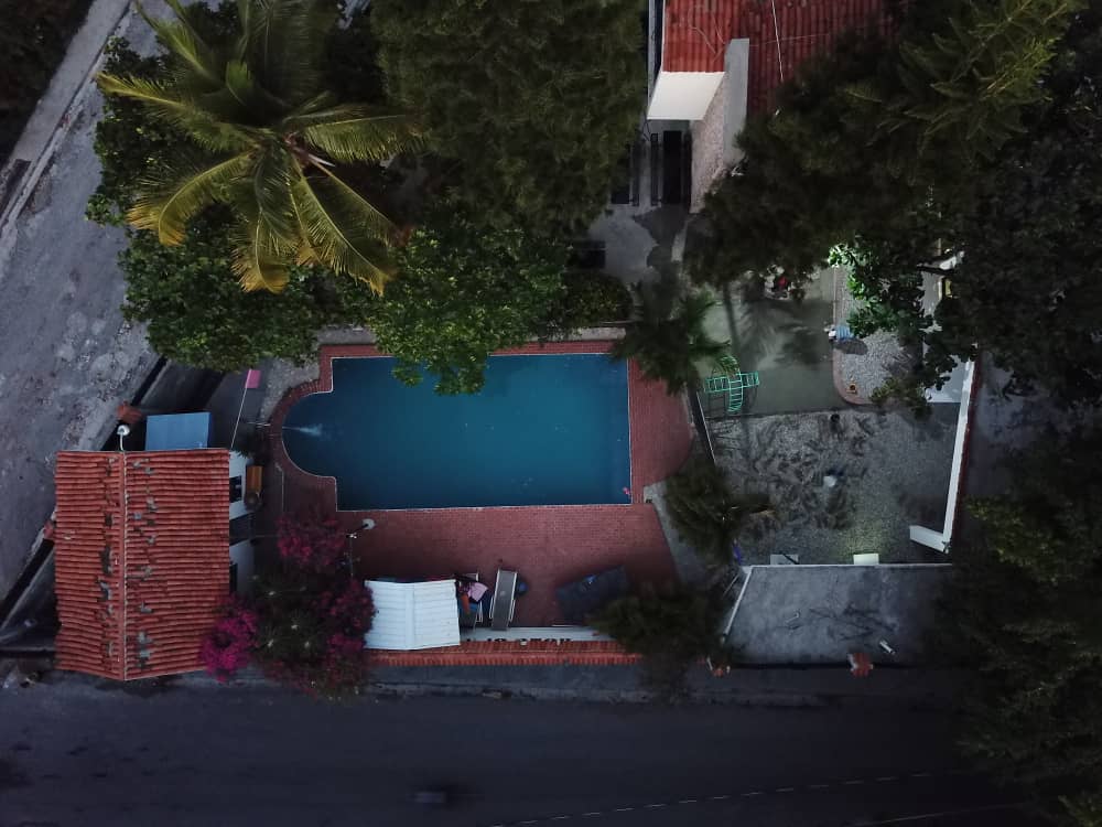 Aerial view of school swimming pool surrounded by tropical greenery