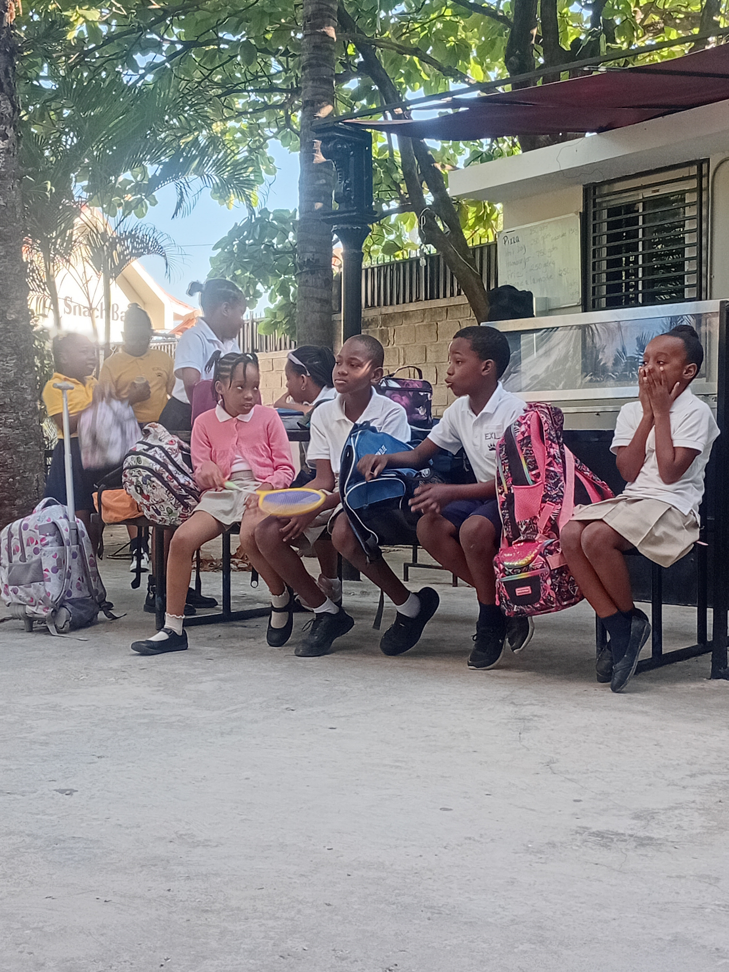 EXL students with backpacks sitting together at the school snack bar
